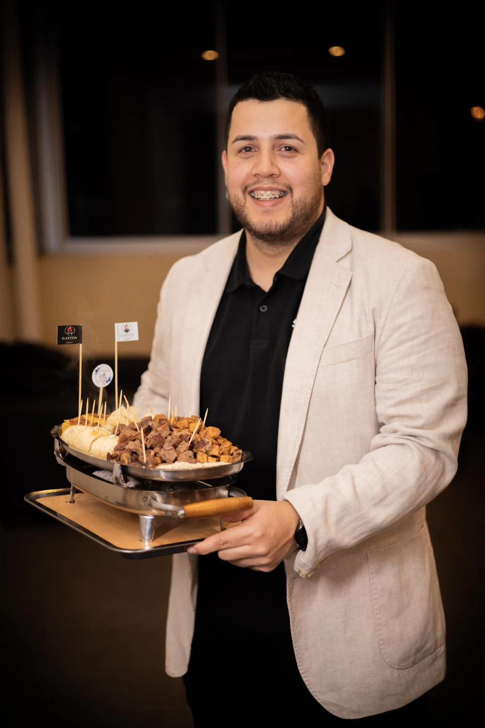 Gastón presentando una parrilla de carnes durante un evento